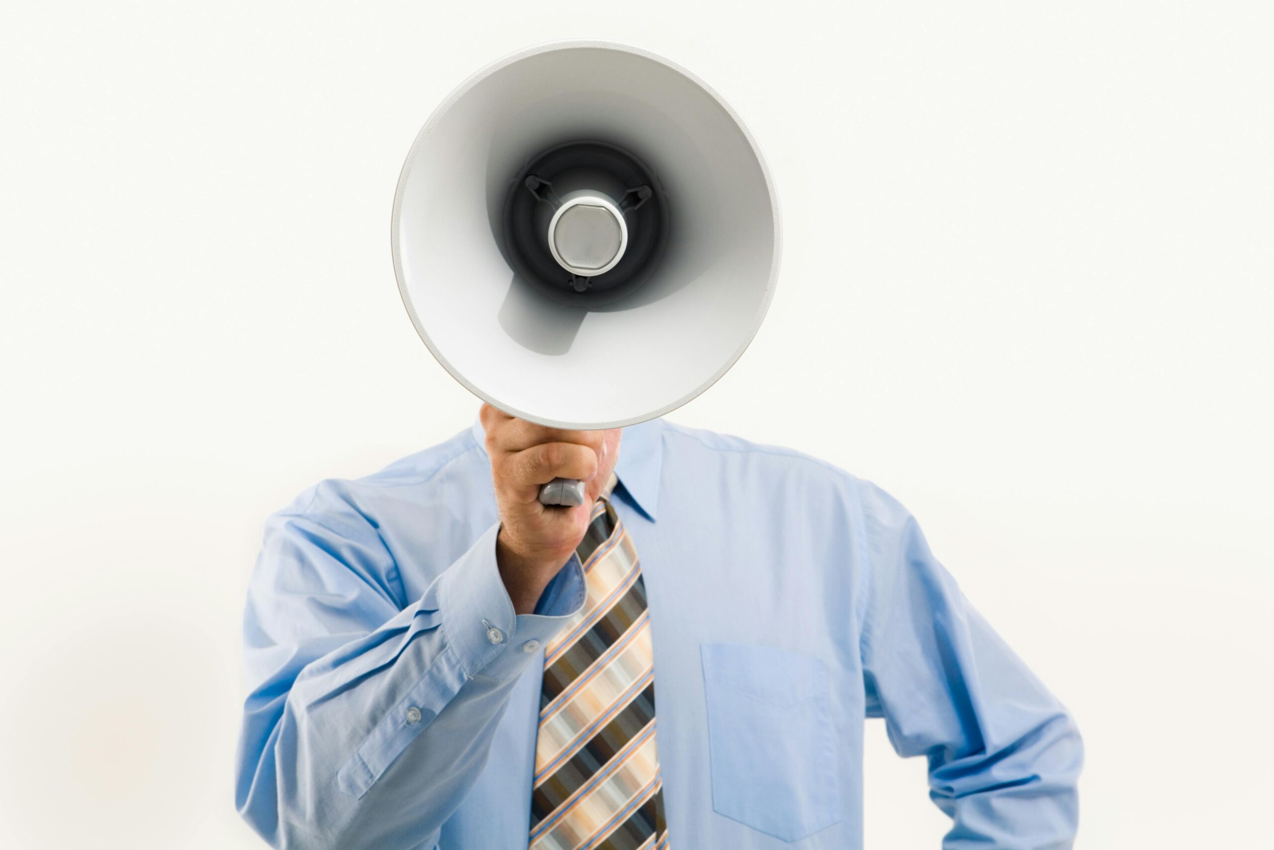 person in suit holding megaphone